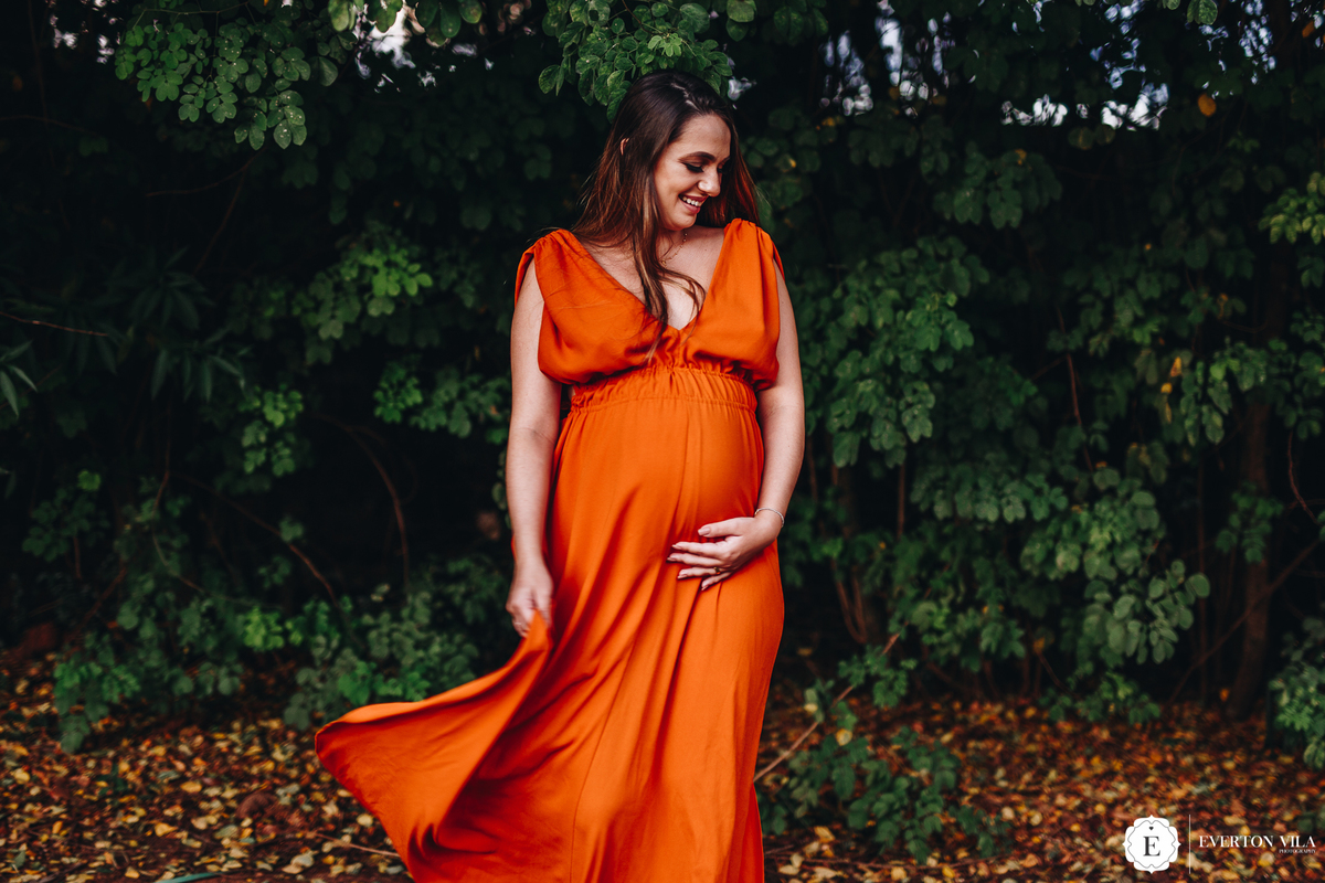fotos de gestante balançando seu vestido laranja em Cianorte-PR