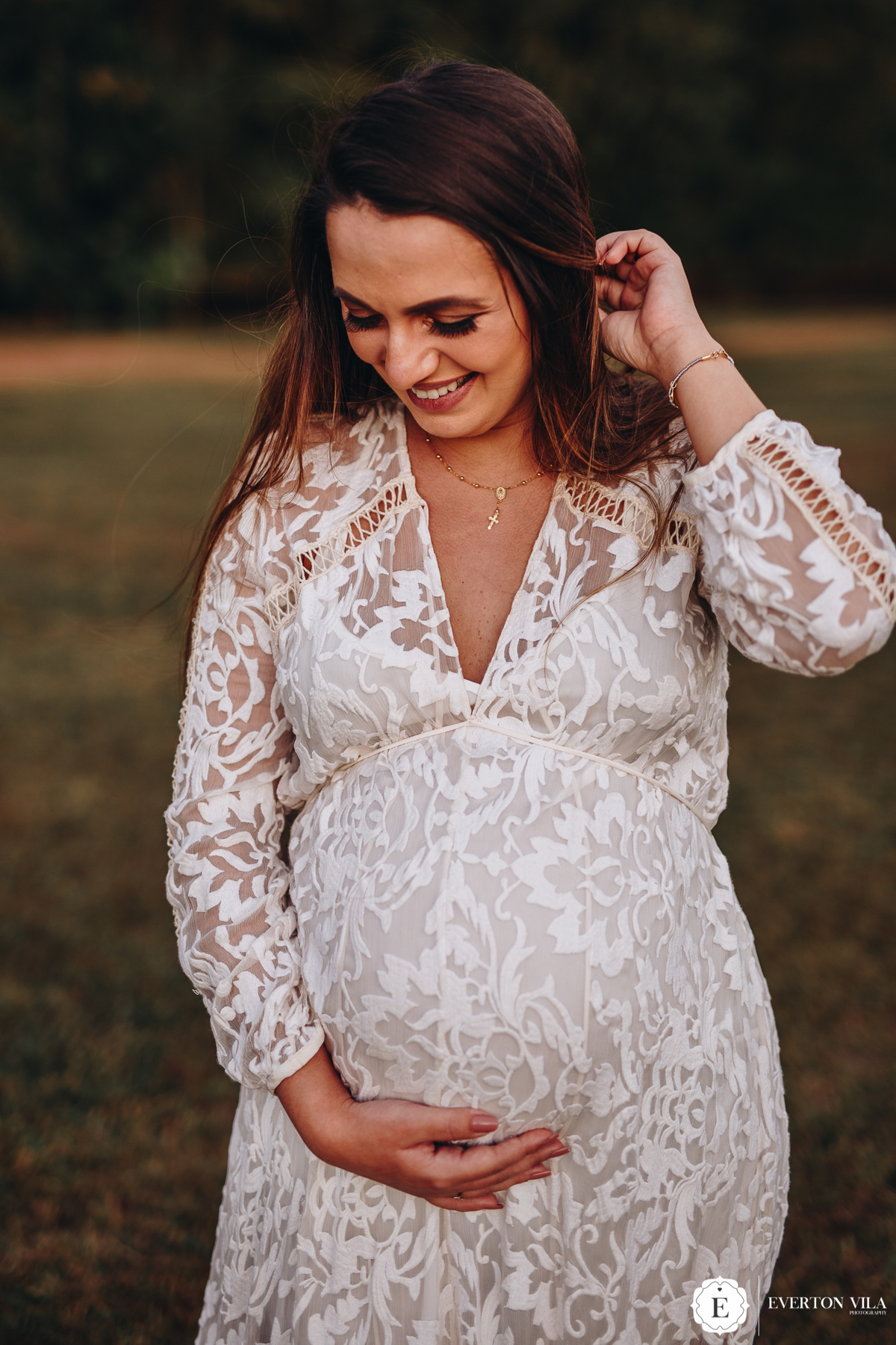gestante feliz com vestido branco em ensaio fotográfico