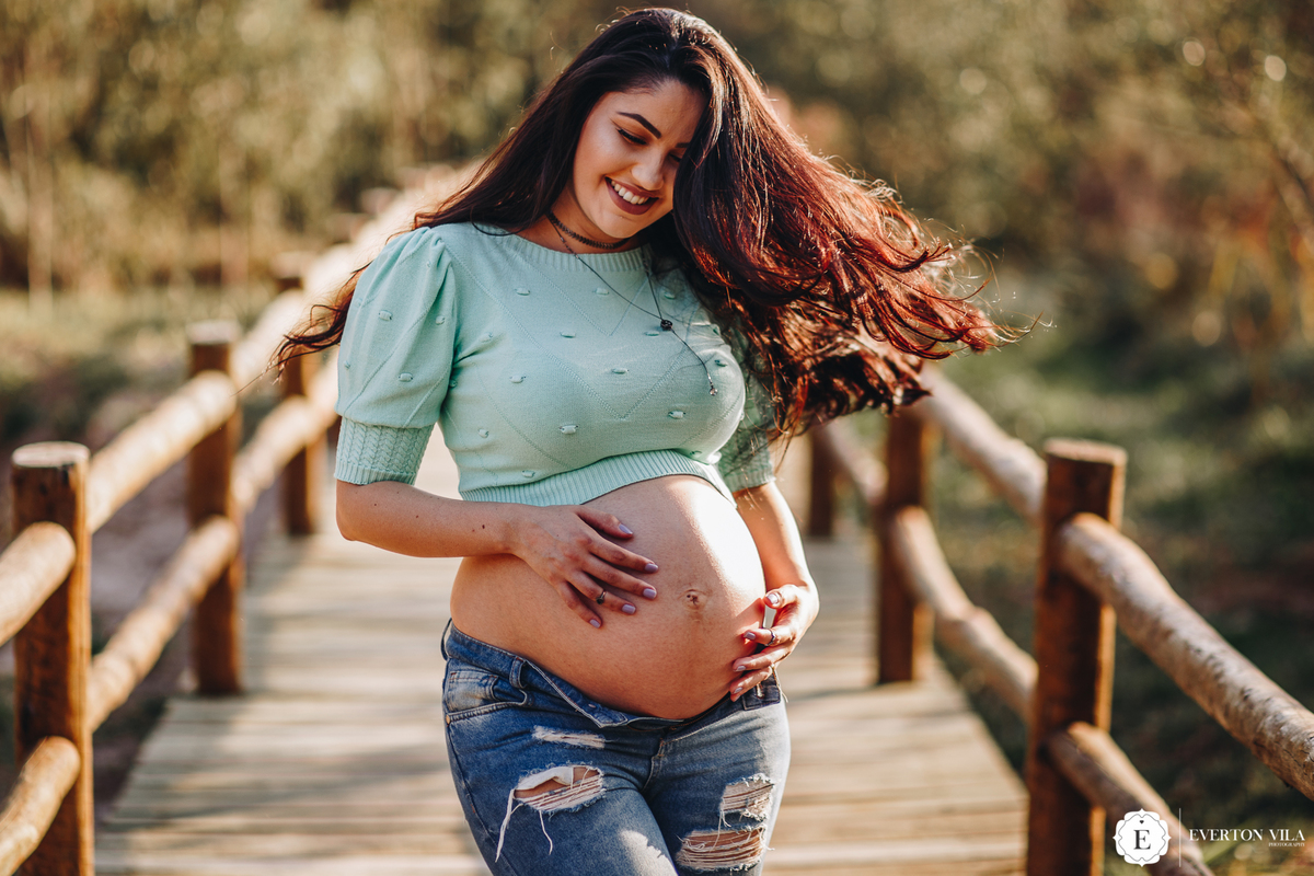 gestante linda balançando seus cabelos em ponte de madeira em Cianorte-pr