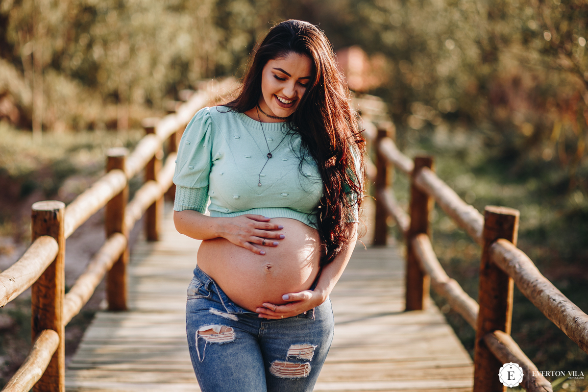 gestante linda e delicada em ponte de madeira no Paraná