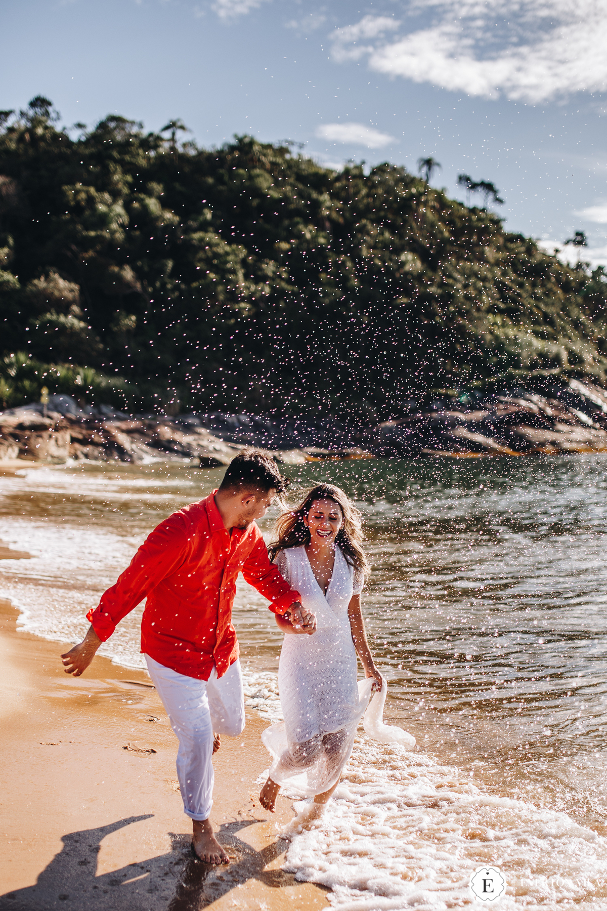 casal correndo na praia de balneário camboriú em ensaio pré wedding