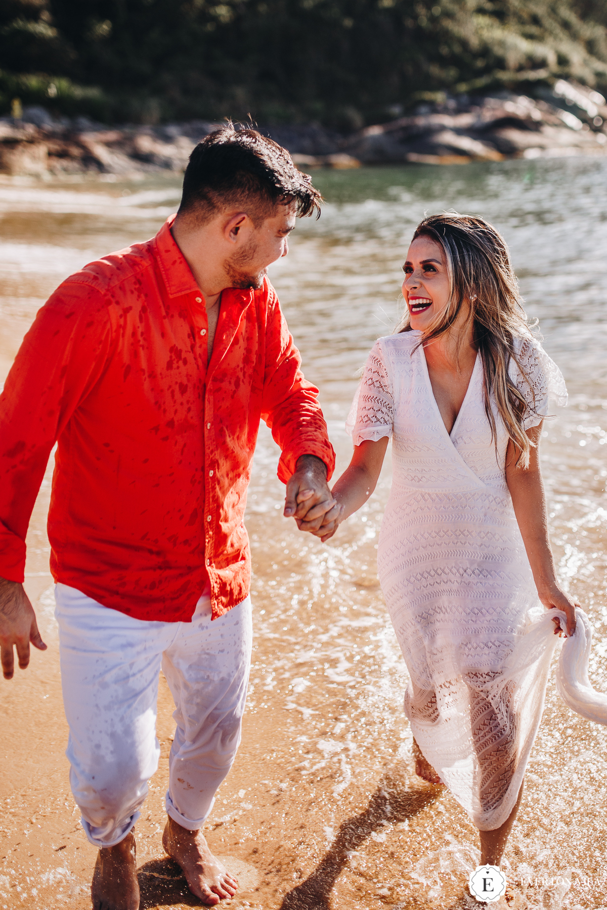 noivos felizes caminhando pelo mar em santa catarina