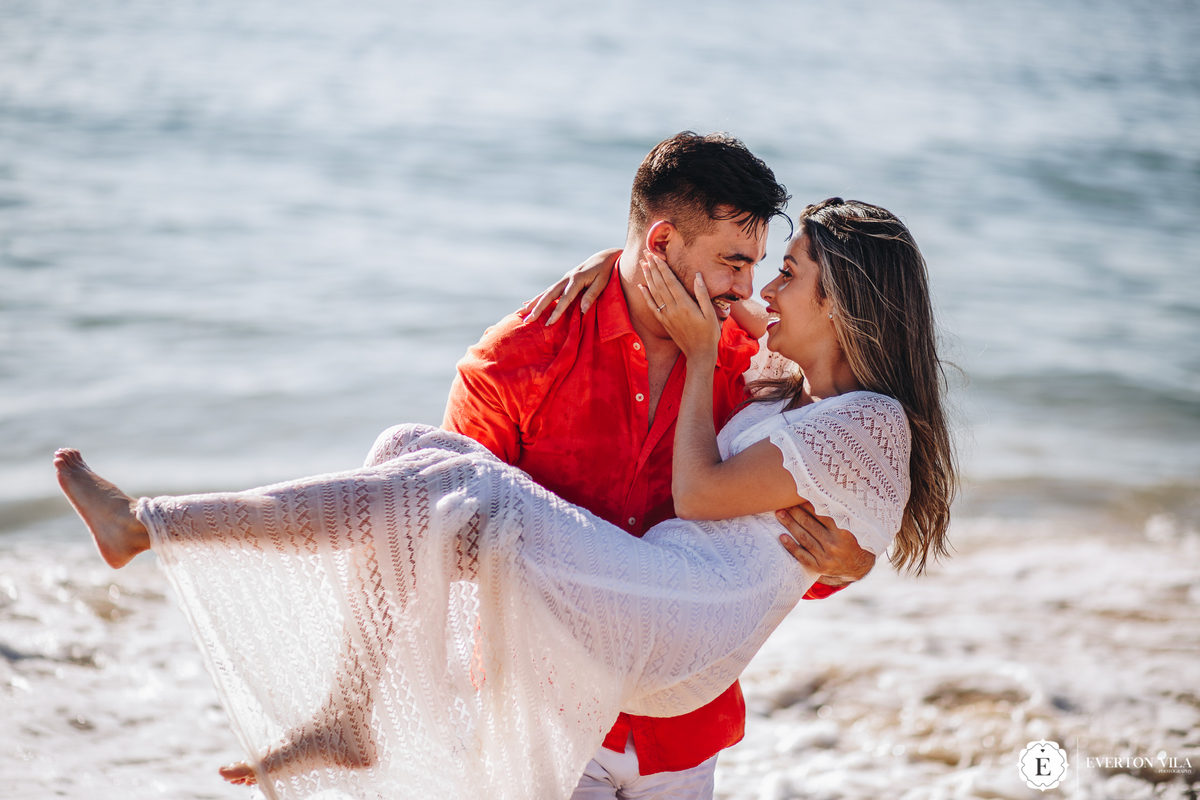 noivo segurando sua noiva no colo em ensaio de casal na praia