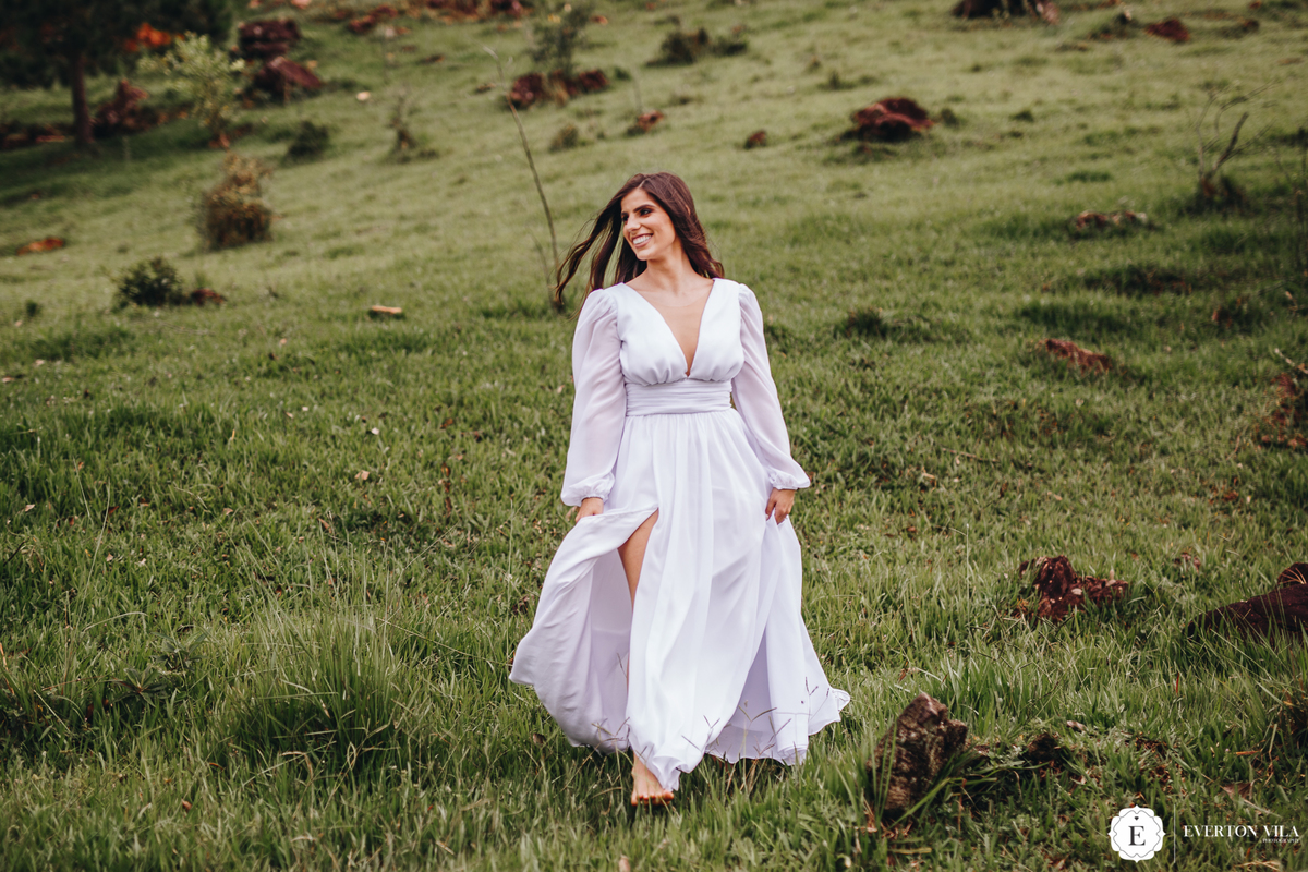 noiva linda caminhando com seu vestido branco em campo