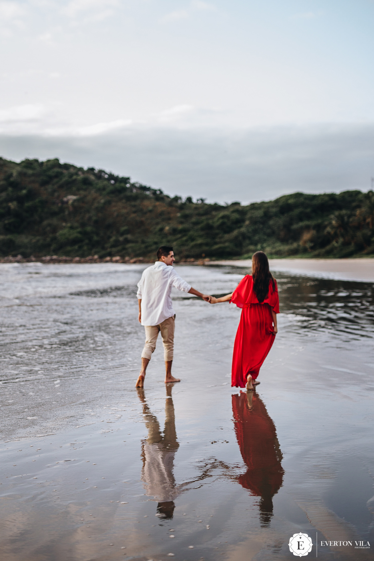 noivos caminhando de mão dadas em praia no parana