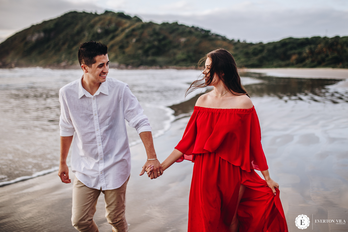 noivos lindos correndo beira mar em praia do brasil