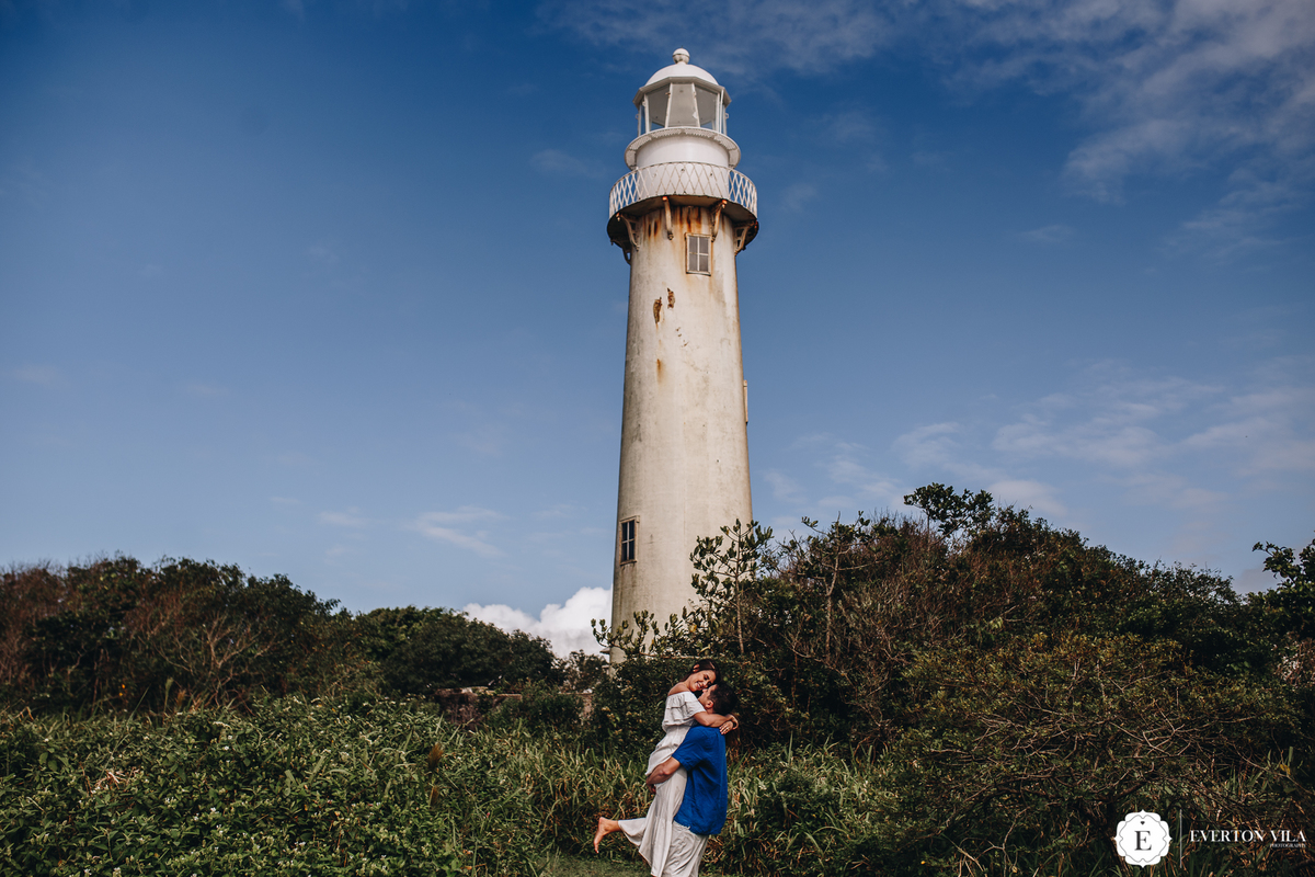 noivo segurando noiva no colo em farol da ilha do mel no paraná