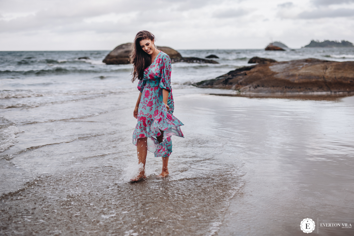 linda noiva caminhando pelo mar com vestido florido em ilha do mel