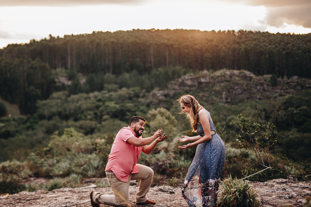 noivo ajoelhando para pedir a mão de sua noiva em casamento em ensaio de fotos