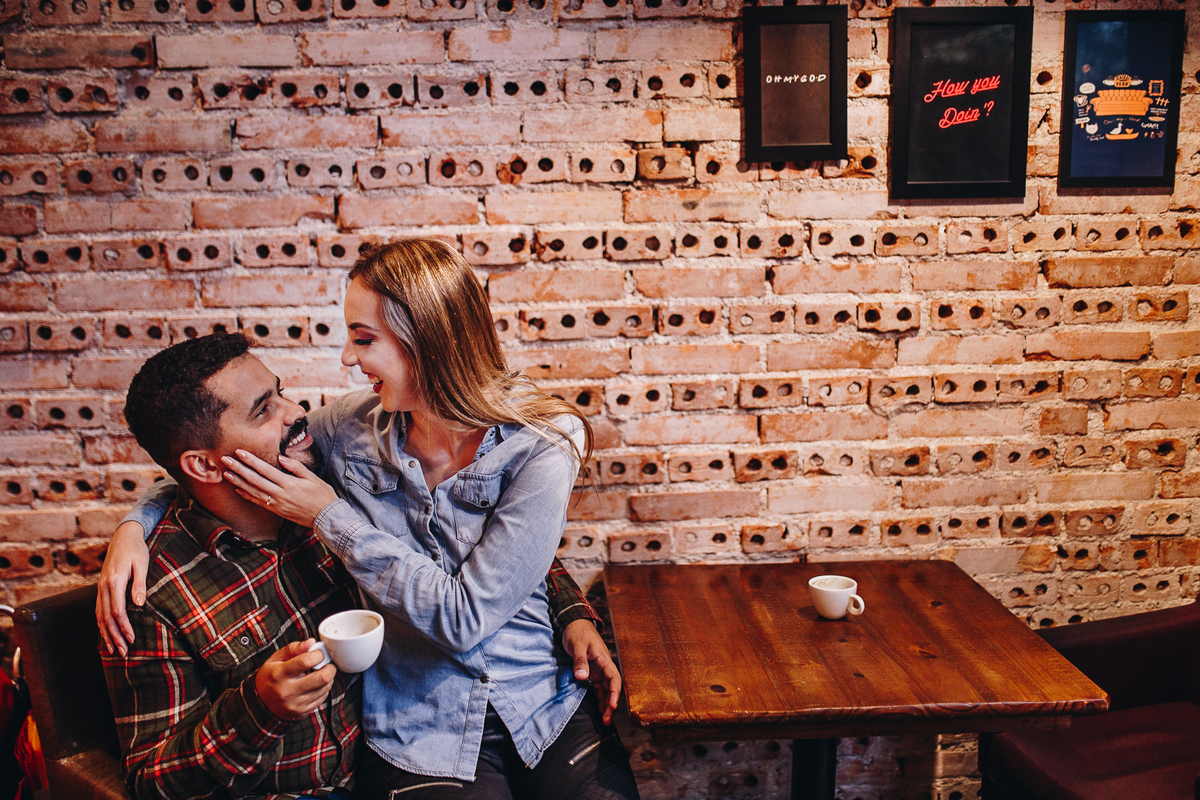 noiva sentada em colo de seu noivo tomando café em padaria no centro de curitiba