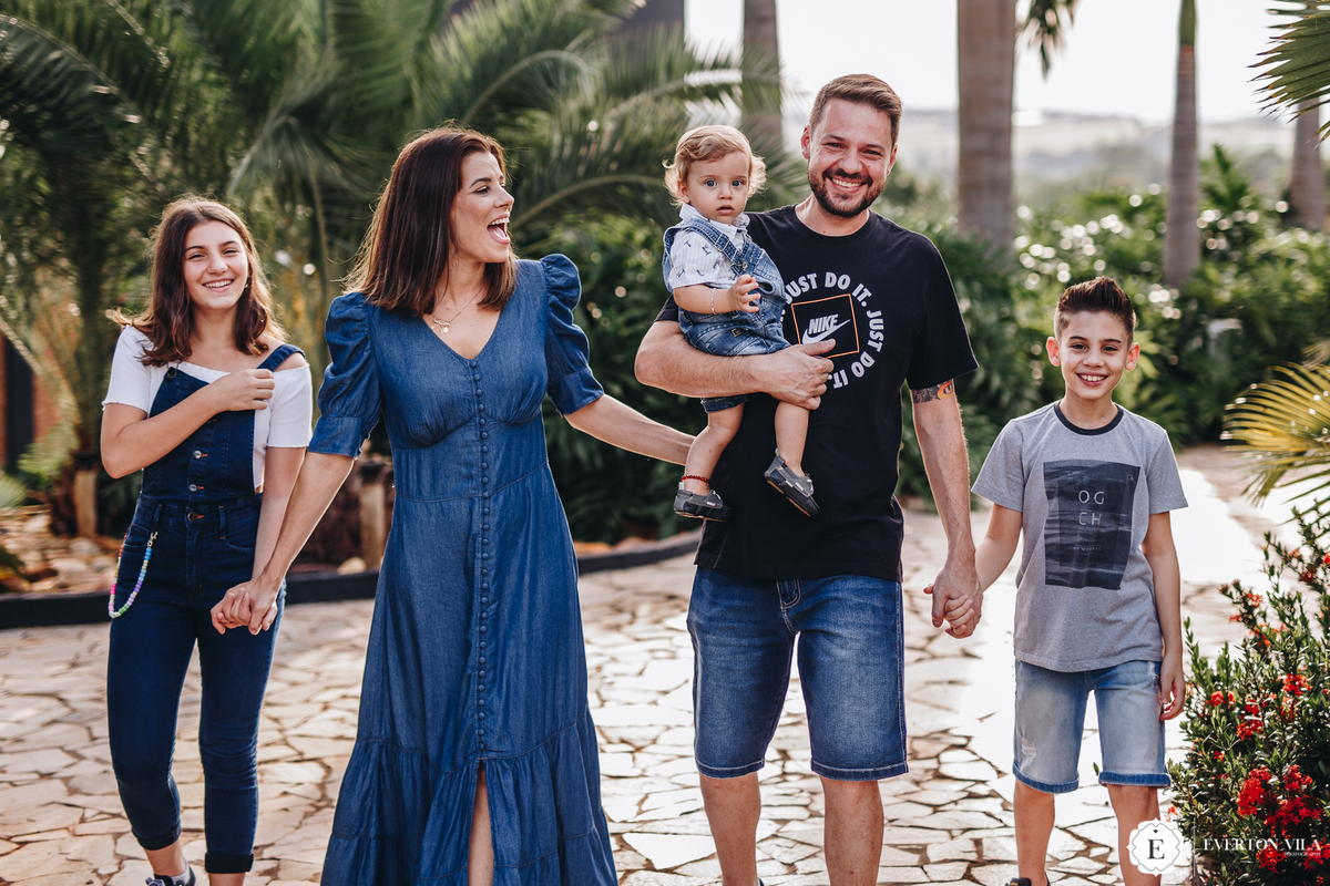família linda de mãos dadas caminhando em chacára real garden