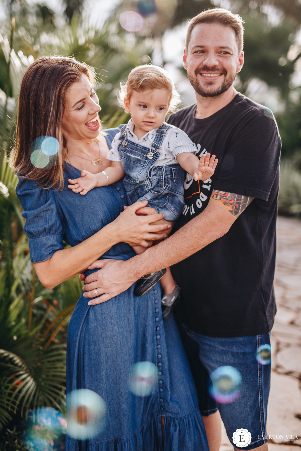 papai e mamãe brincando com seu pequeno filho em ensaio no paraná