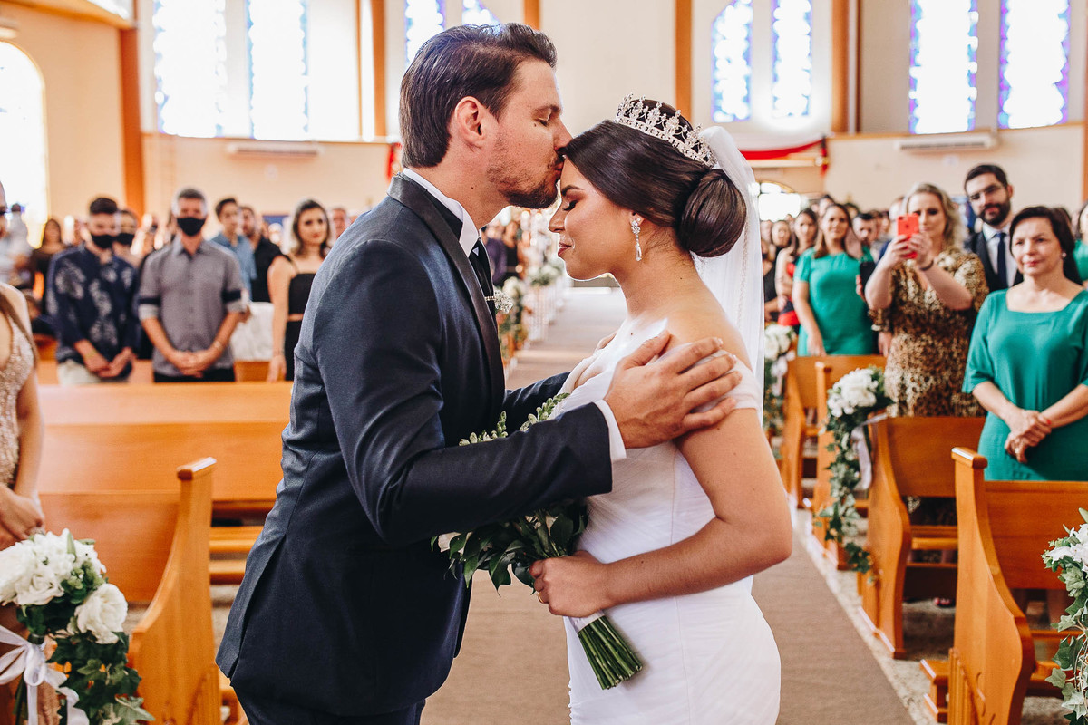 noivo beijando testa de sua noiva em casamento na igreja