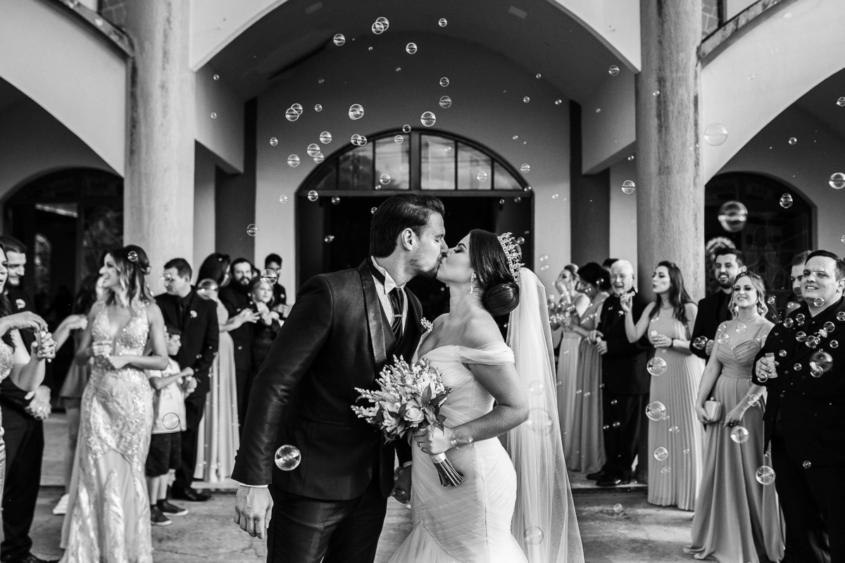 lindo beijo dos noivos com bolinhas de sabão 