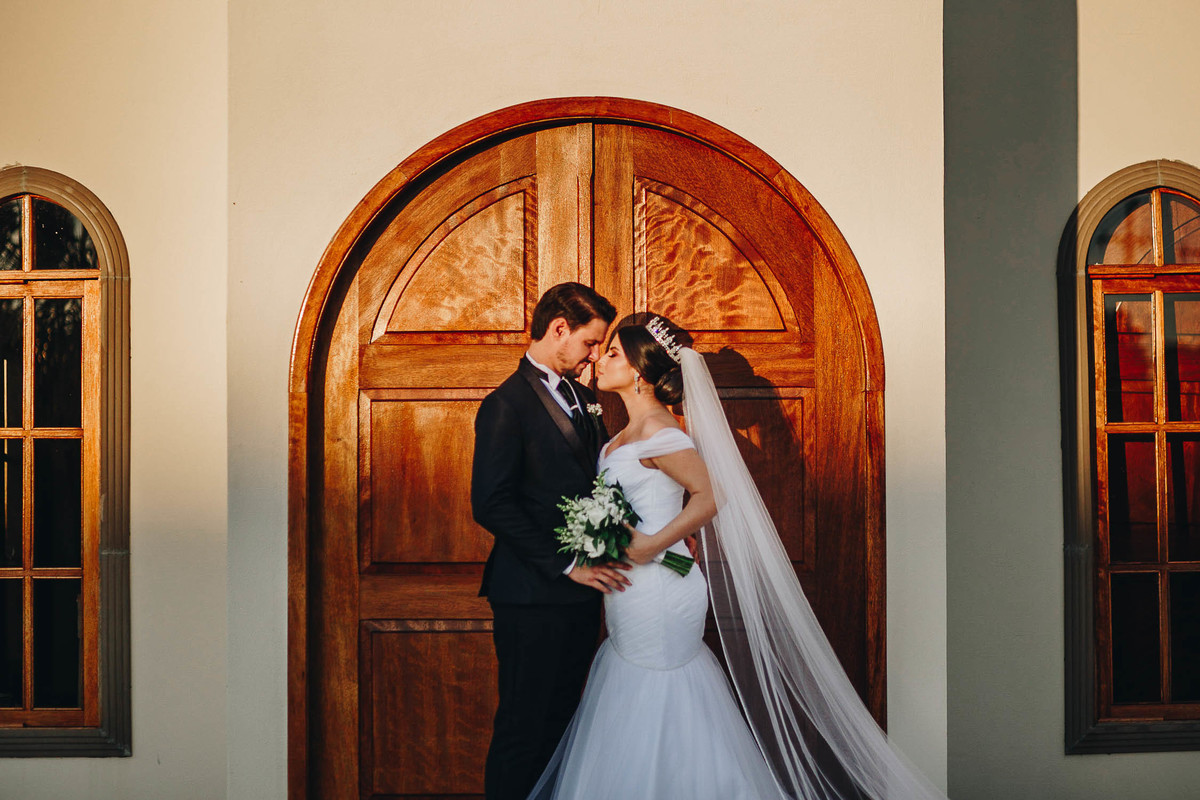 casal abraçados em porta de madeira linda em igreja no campo