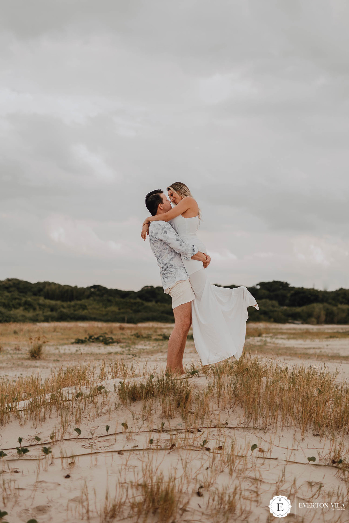 noiva feliz em colo de seu noivo para ensaio de casal