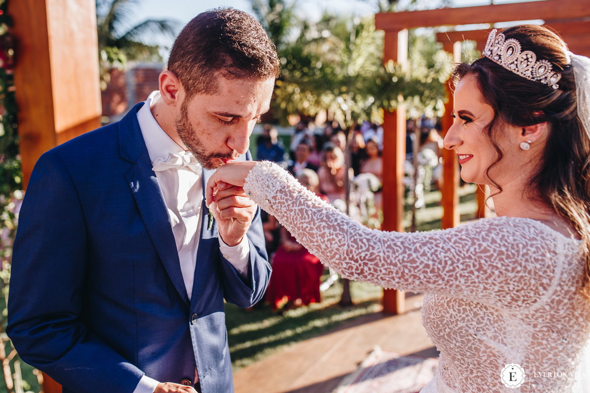 noivo beijando mão de sua noiva em troca de alianças 