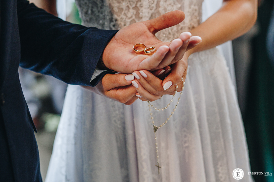 noivos segurando as alianças em casamento