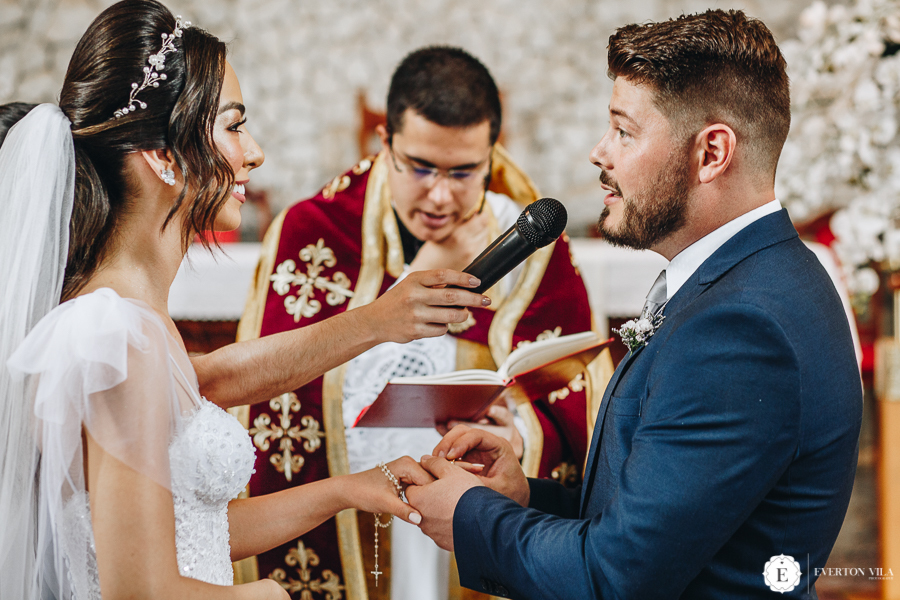 noivo colocando aliança na mão de sua noiva