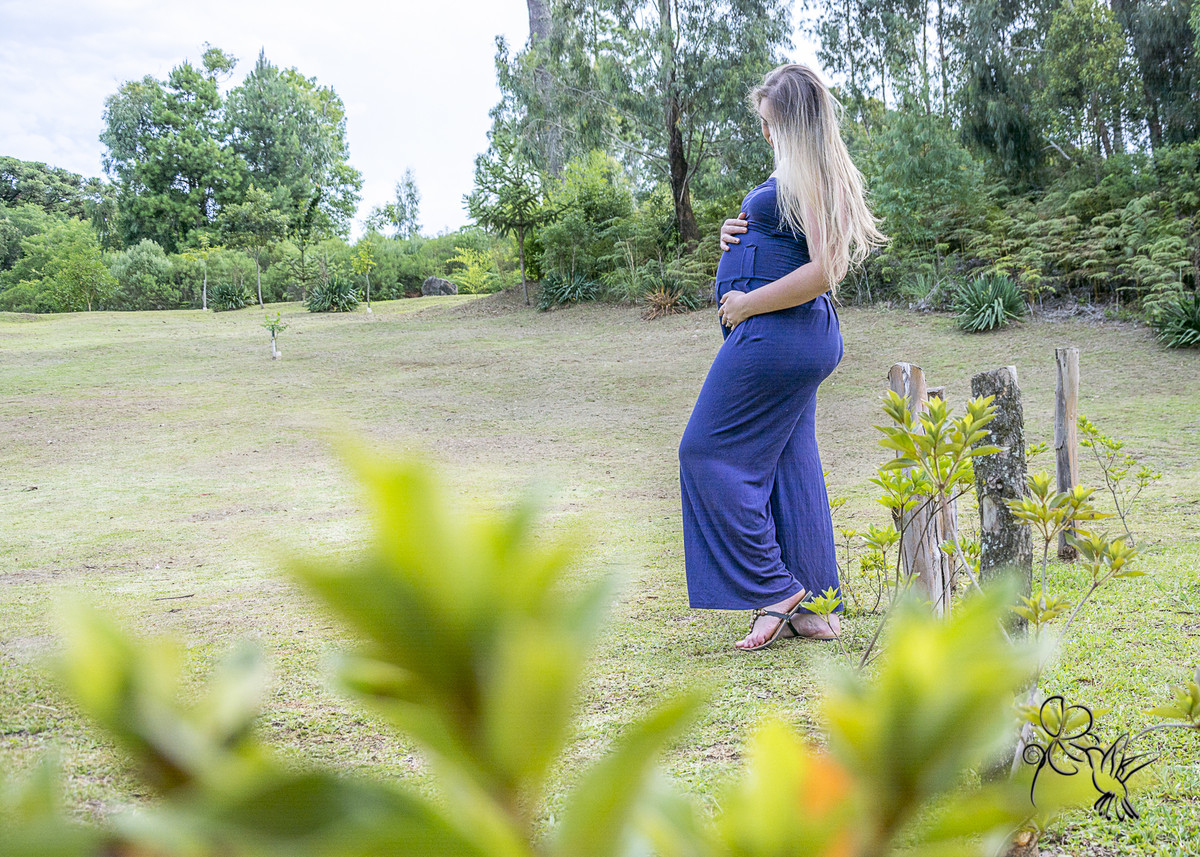 mãe GESTANTE de macacão azul de pé em um gramado por BY ELI MATOS FOTÓGRAFA