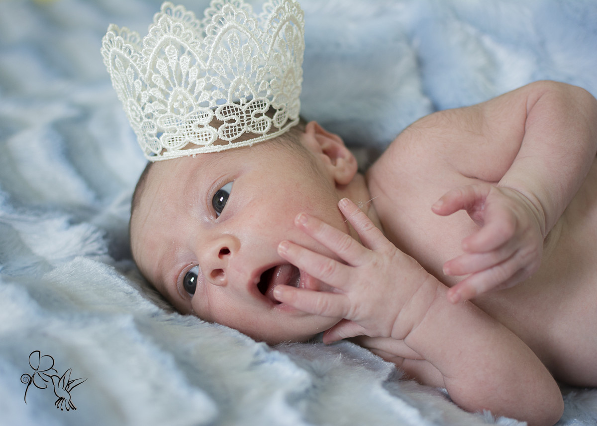 BEBÊ com coroa clicado pela FOTÓGRAFA DE FAMÍLIA BY ELI MATOS coloca a mão na boca