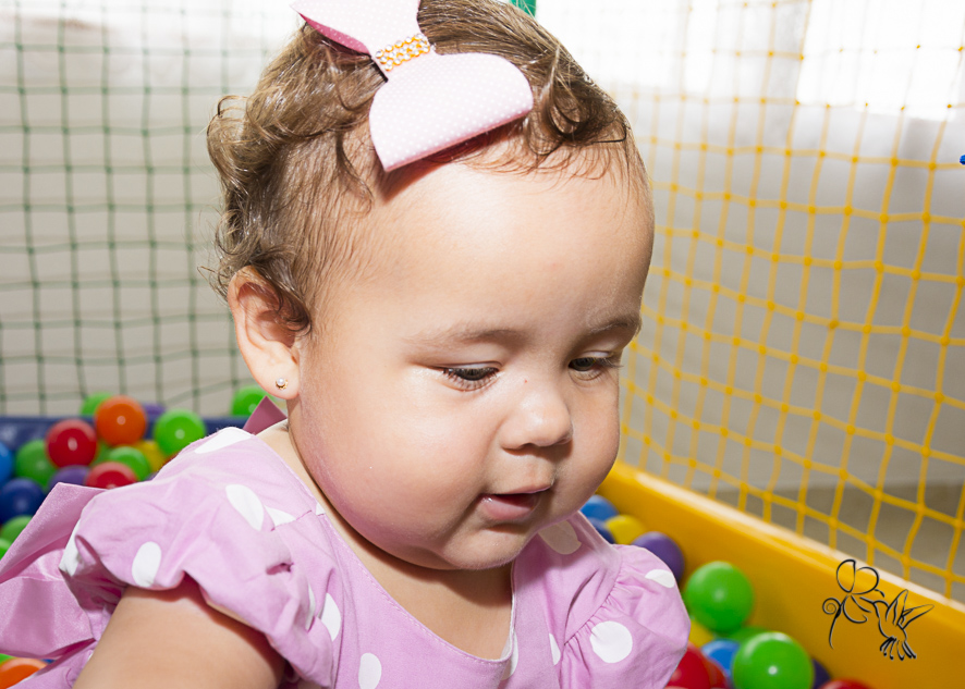 by Eli Matos fotografa Manuela na sua festa de um aninho, ela olha para as bolinhas coloridas