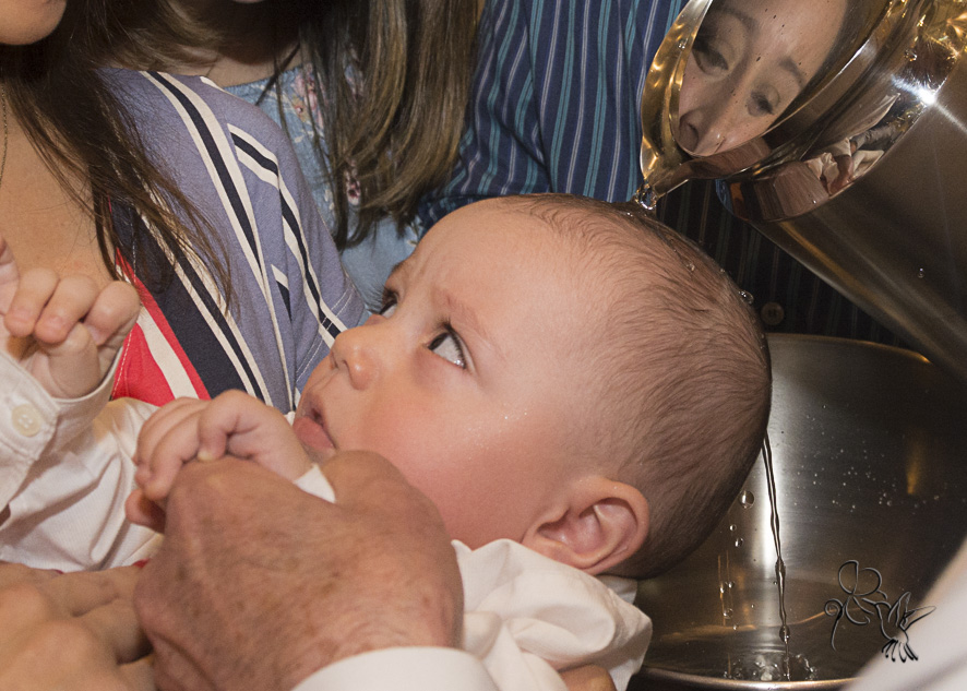 by Eli Matos registrou momento  que o padre derrama a água na cabeça em seu batizado
