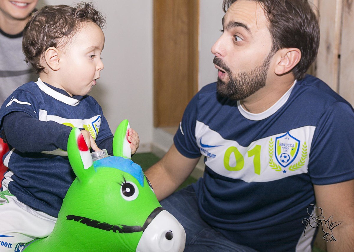 by  Eli Matos clica, Pai e filho fazendo cara de espanto com brinquedo pula pula verde