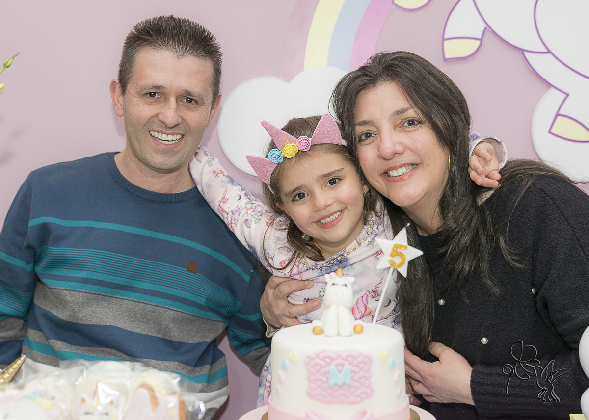 Papai e mamãe abraçam a Marília no seu aniver de 5 anos, todos sorriem, clique de by Eli Matos