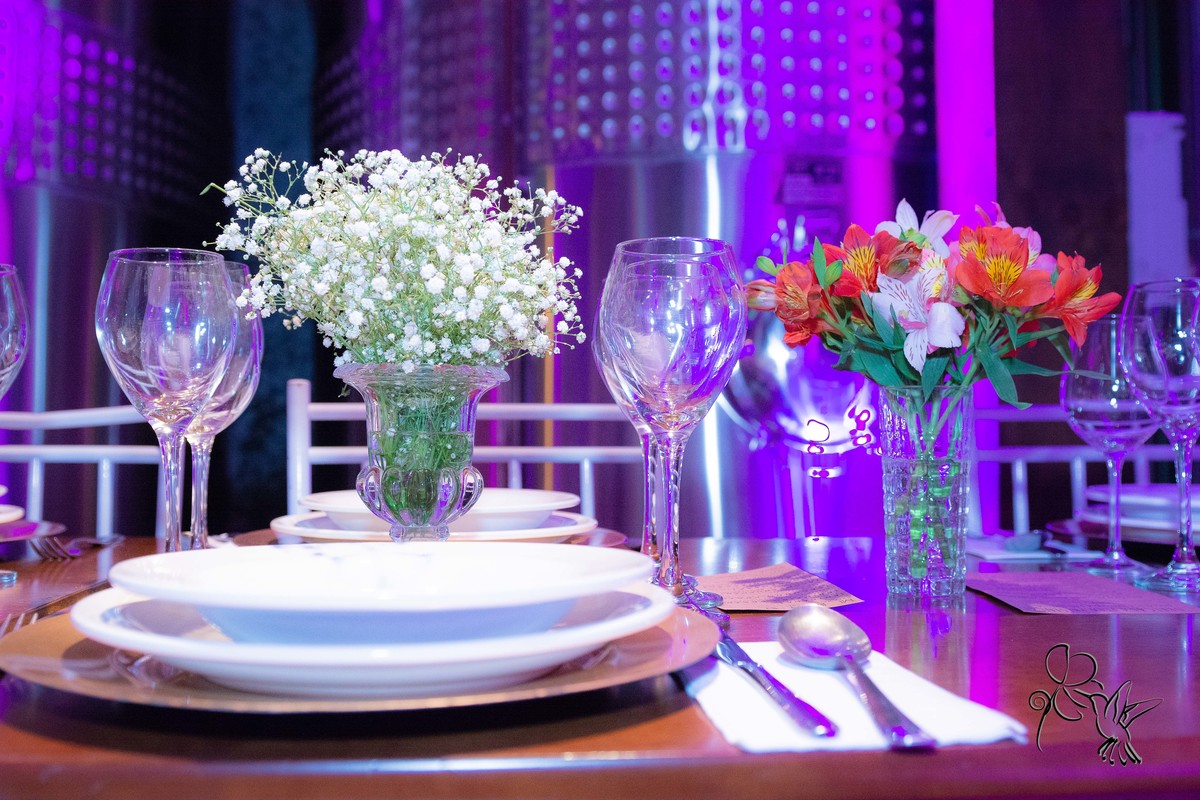 detalhe da mesa decorada para as formandas e ao fundo barris de vinho,  salão dentro de uma catina clicado por de by Eli Matos clicou