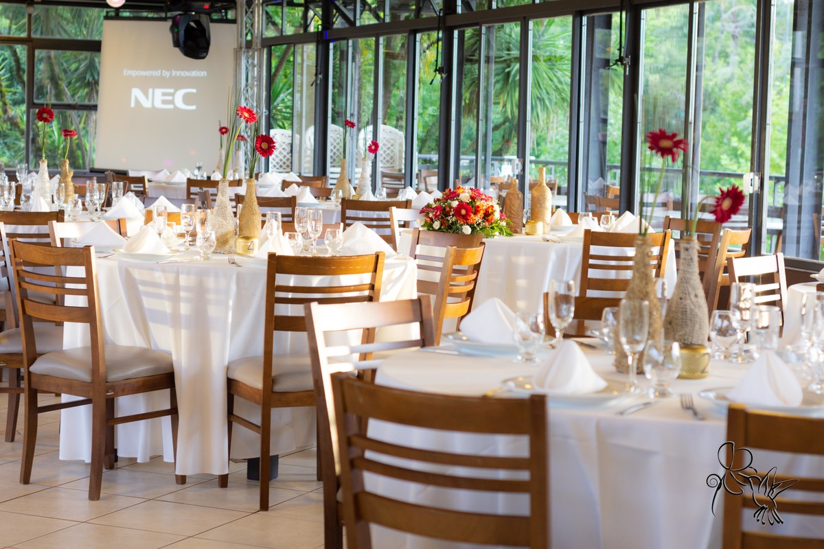 Salão decorado para formatura de Odontologia, no clique de  by Eli Matos, mesas com toalhas brancas e cadeiras cor madeira