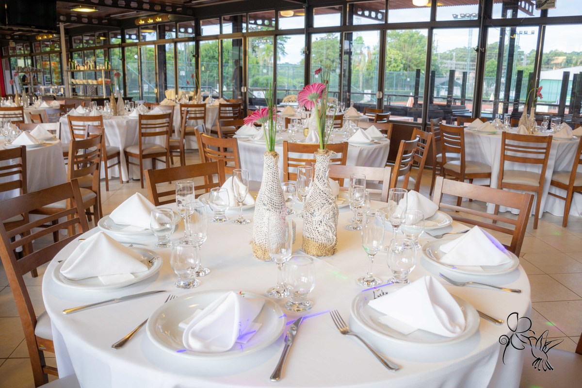 Salão decorado para formatura de Odontologia, no clique de  by Eli Matos, mesas com toalhas brancas e cadeiras cor madeira