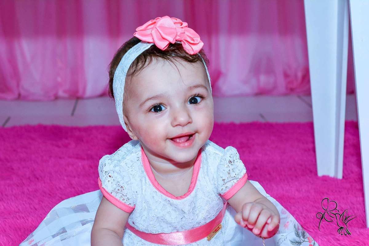 Cecilia faz um ano e sorri muito alegre num vestido branco com flores rosas, by Eli Matos, registrou esse sorriso