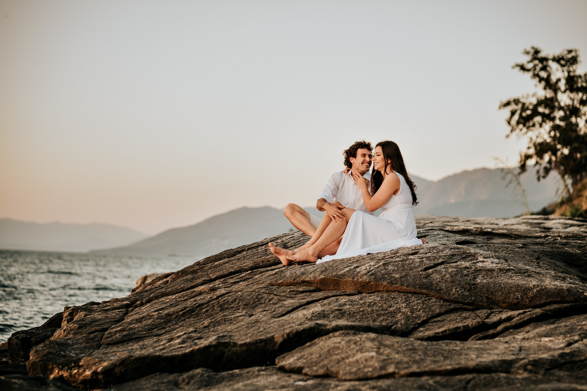 Ensaio Pré-wedding em Ilhabela, noivos na pedra da praia, por do sol, final de tarde.