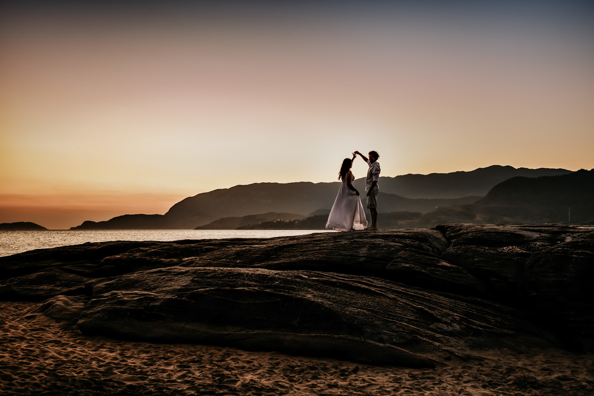 Ensaio Pré-wedding em Ilhabela, noivos na pedra da praia, por do sol, final de tarde.