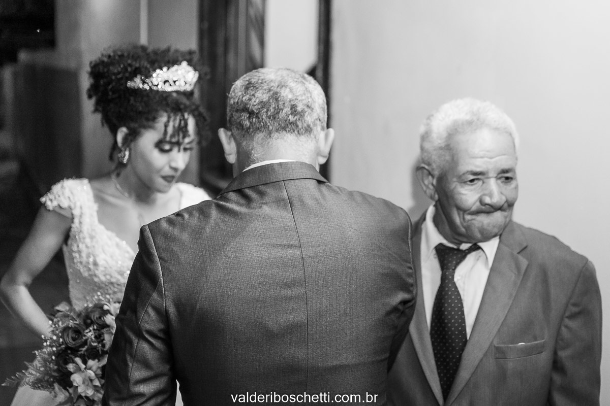 Foto da noiva Cris com seu avó e seu pai entrando no seu casamento realizado na Igreja Maranata em Nova Lidice - Medeiros Neto - BA
Fotografia Valderi Boschetti