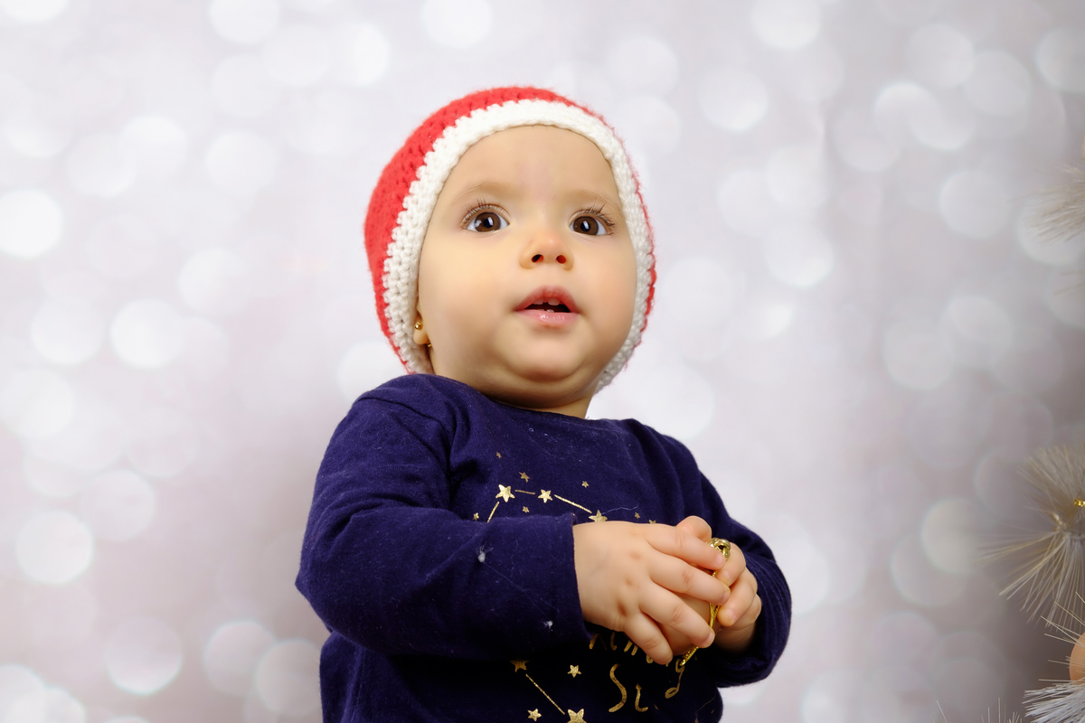 Vitória na sessão fotográfica de natal com ar admirado 