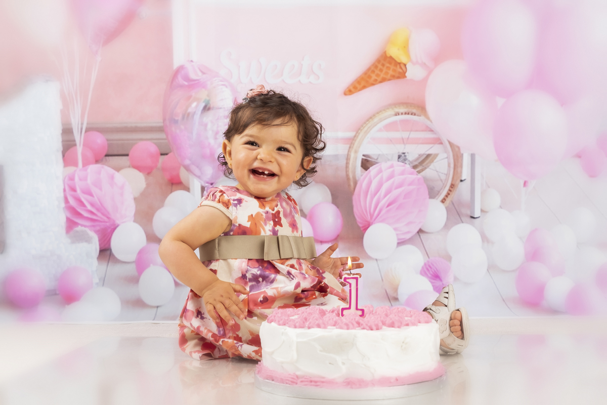 Bebé com o bolo de aniversário no estúdio