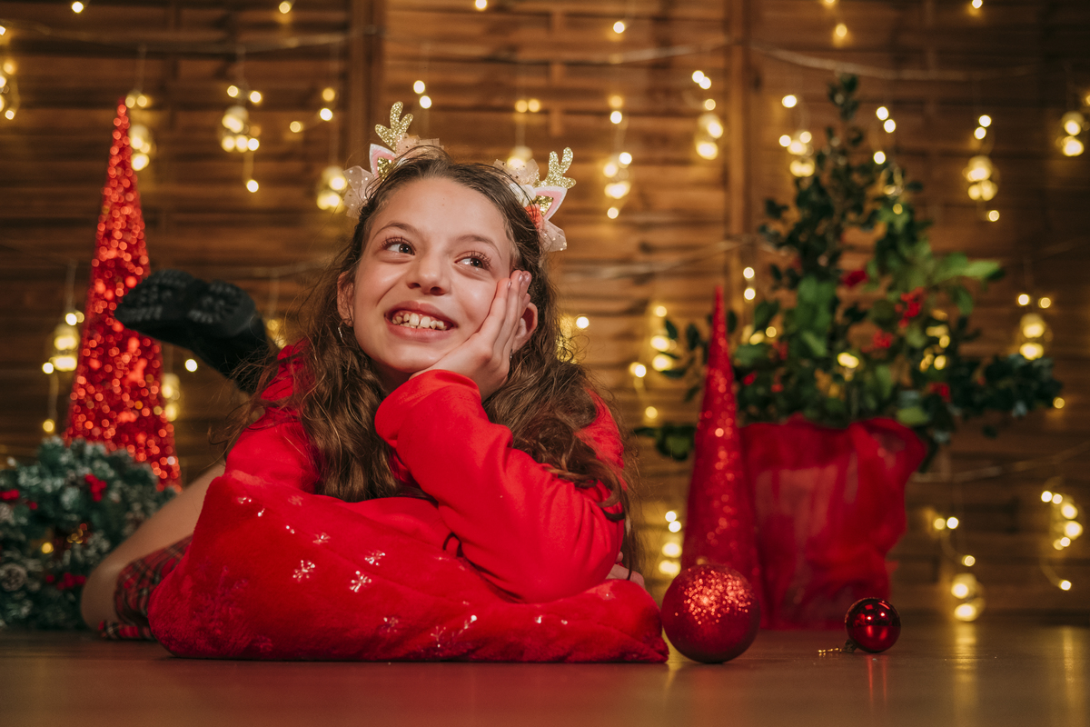 Criança na sessão fotográfica de estúdio com cenário de natal