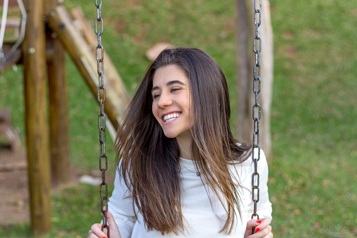 Sentada em um balanço na praça defronte da igreja de Hamburgo Velho 