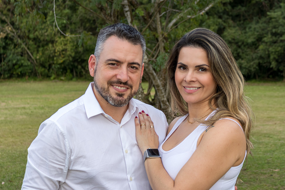 casal lado a lado ela com a mão esquerda no peito dele ambos olhando para frente