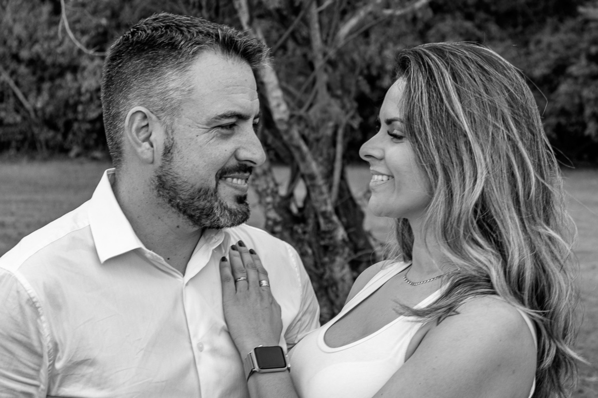 casal lado a lado olhando um para o outro ela com a mão esquerda no peito dele. Foto em preto e branco