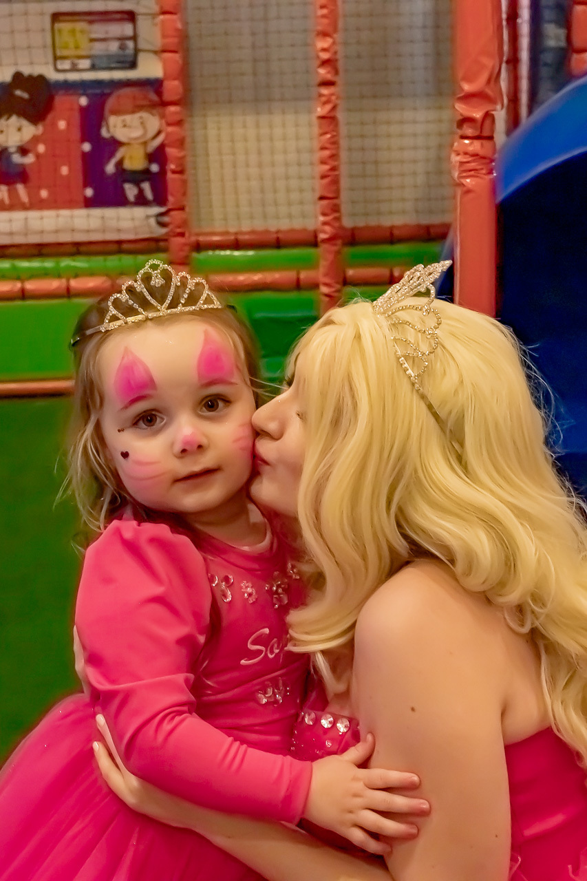 Barbie princesa beijando rosto da aniversariante que está vestida de Barbie também