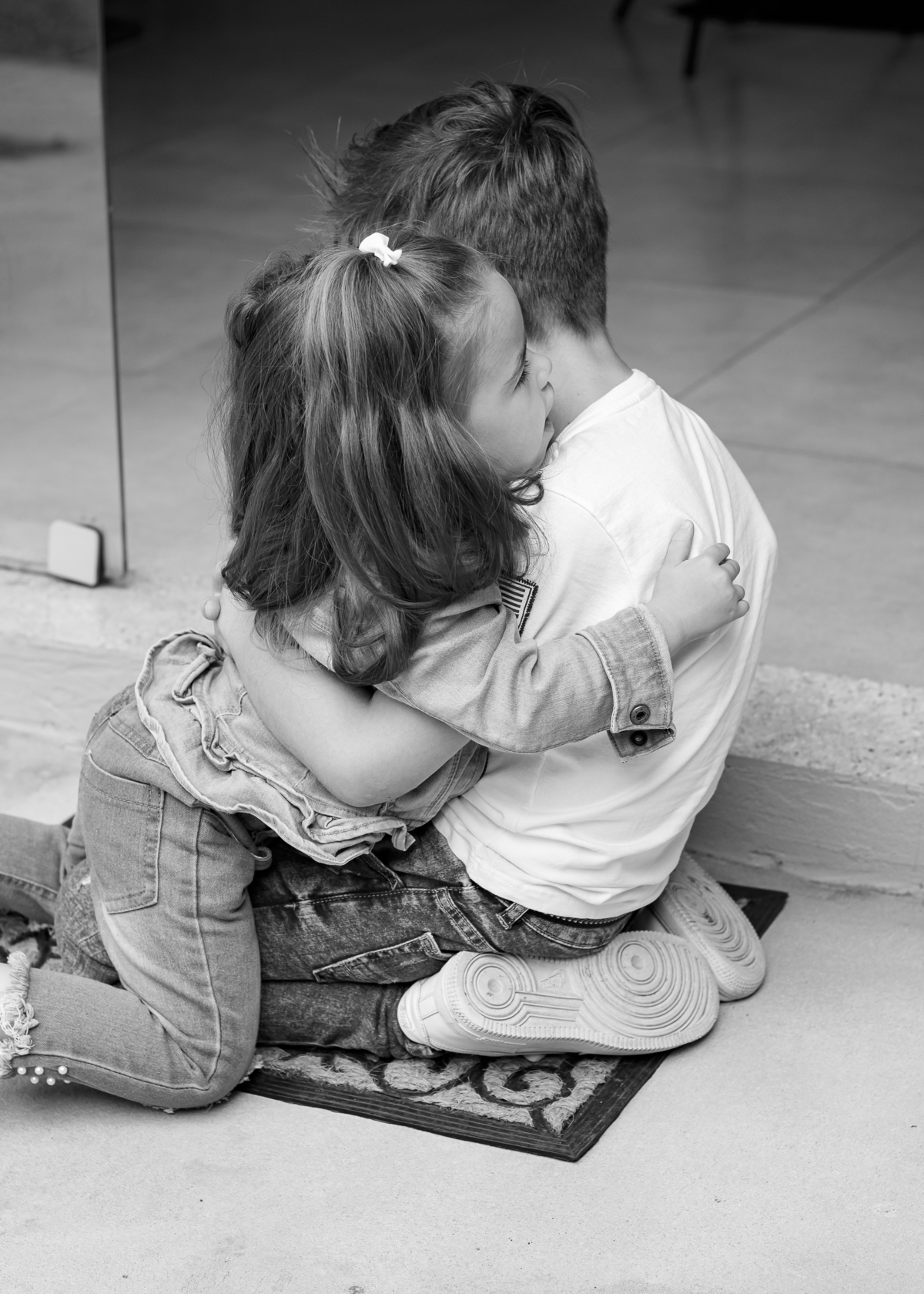 foto em preto e branco irmão de joelhos de frente um para o outro se abraçando