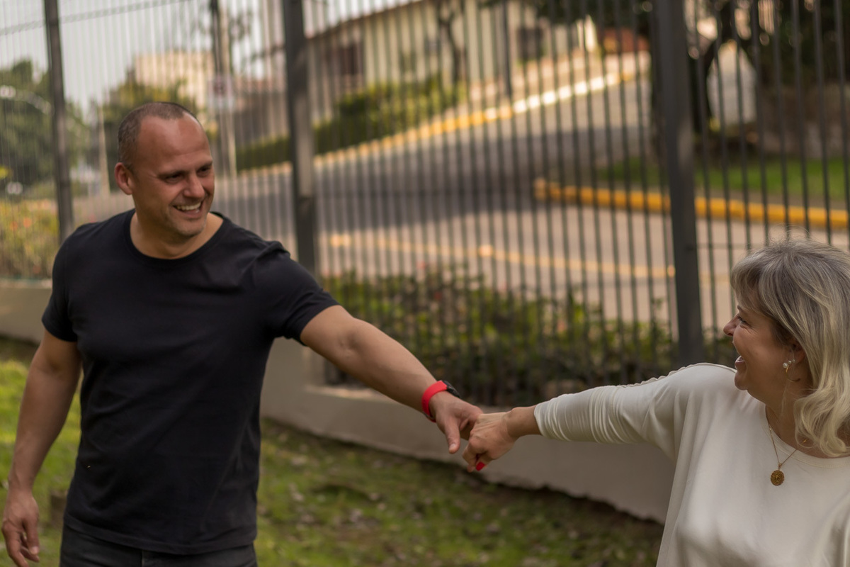 foto externa de casal . ela olhando para tras puxando na mão dele e ambos se olhando. Foto em Novo Hamburgo RS