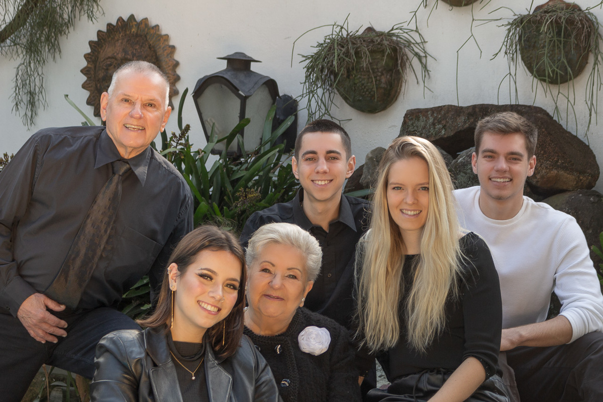 foto posada com um casal de avós e 4 quatro netos. olhando para a câmera.