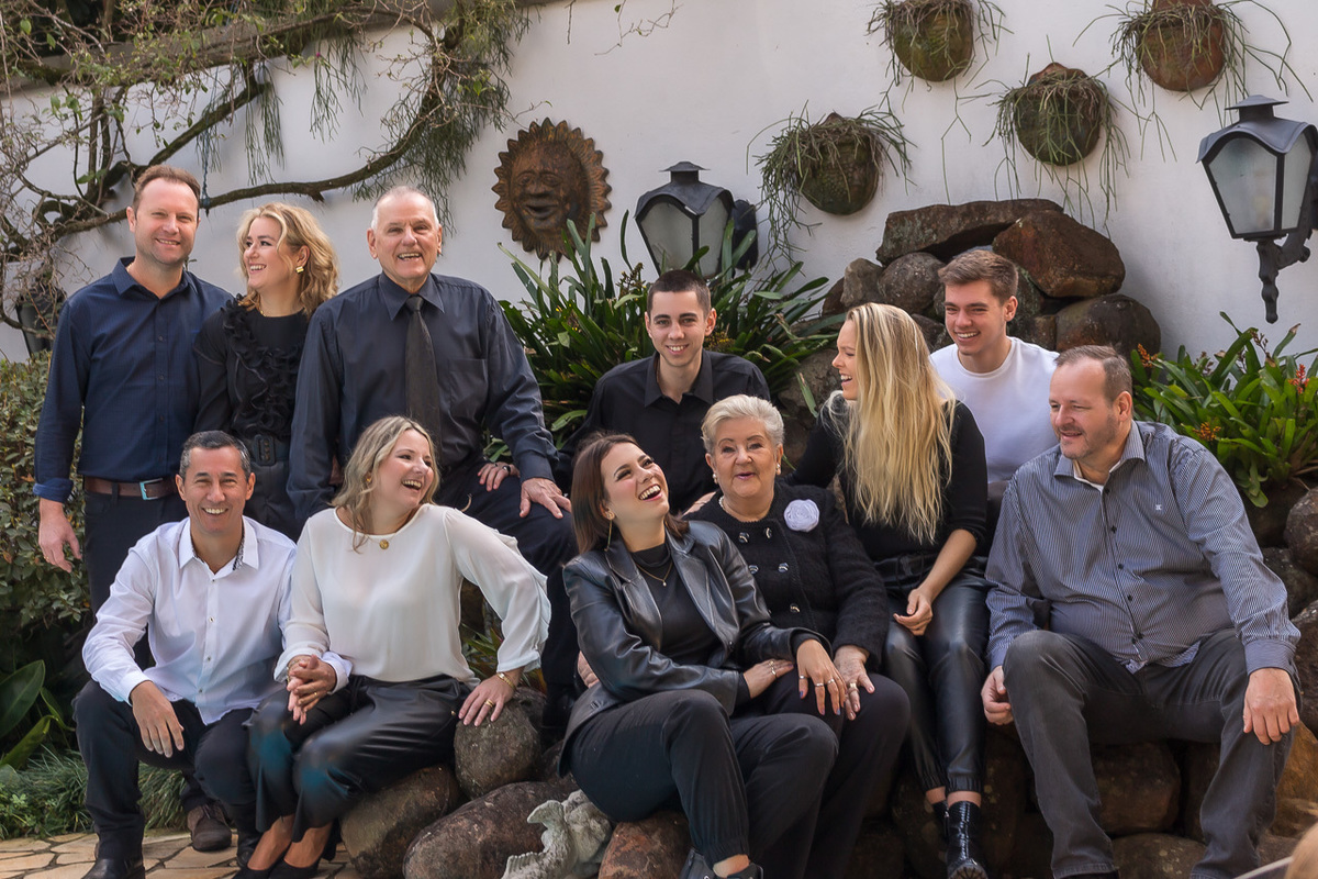 11 pessoas. 7 sentadas/agachadas e três em pé. estão bem descontraídas olhando uma para as outras