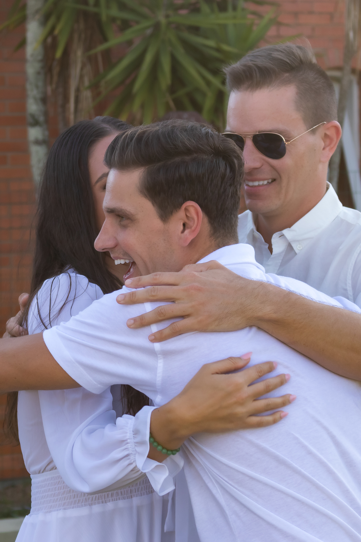 irmão abraçando o casal para agradecer o convite de ser padrinho de casamento