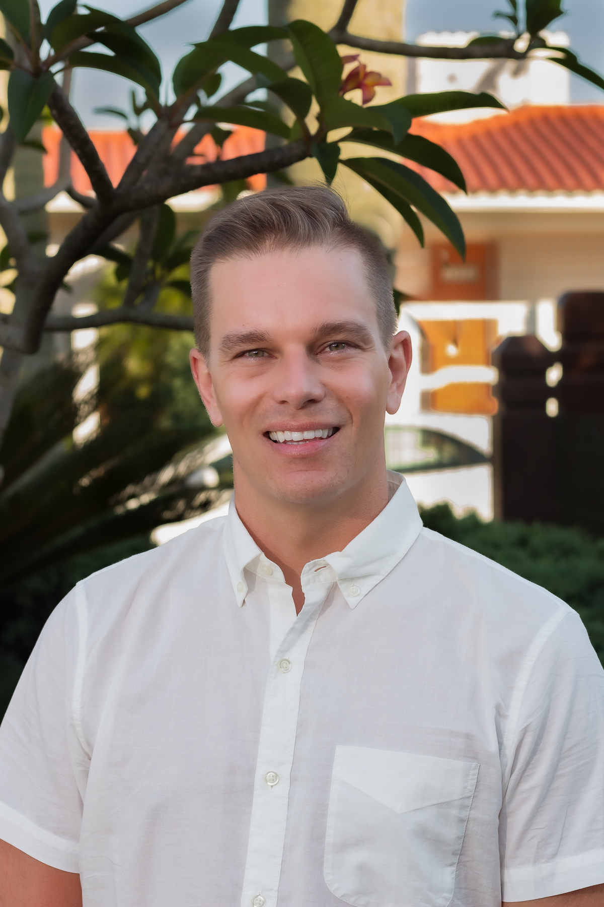 rapaz cabelo castanho olhando para lente e sorrindo levemente