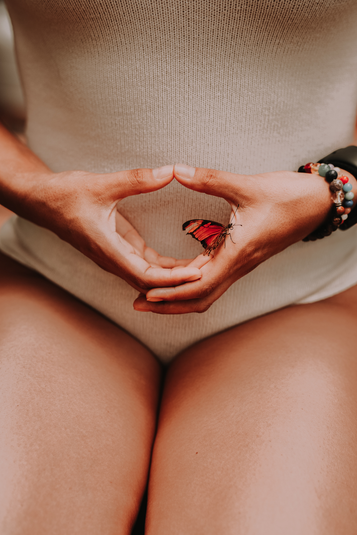 Mulher fazendo Yoga com a borboleta nas mãos